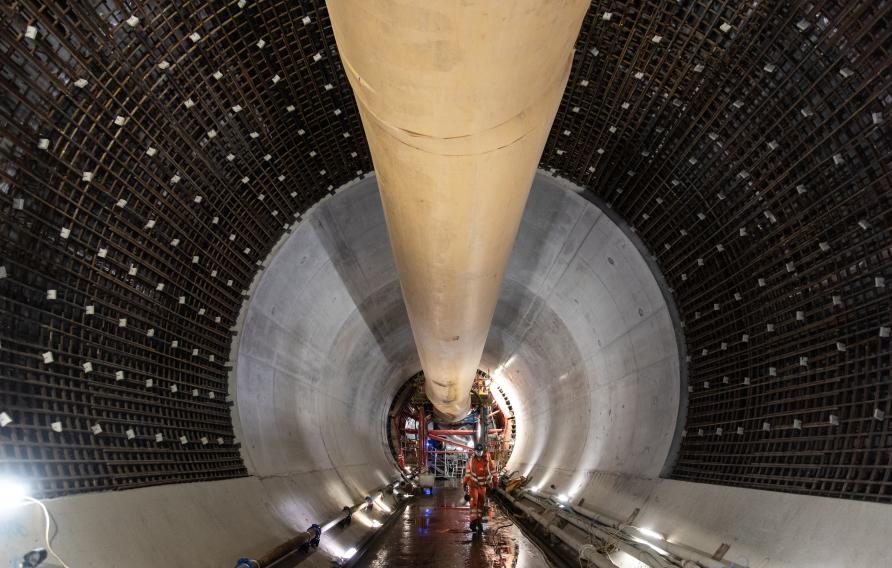 Worker in orange his vis workwear walking in tunnel