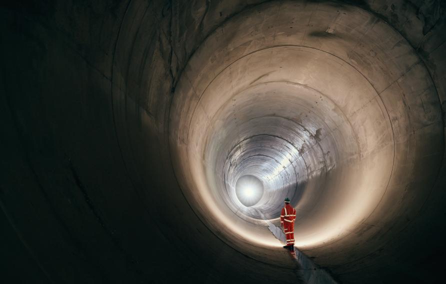 Worker standing in a sewer tunnel before operation.