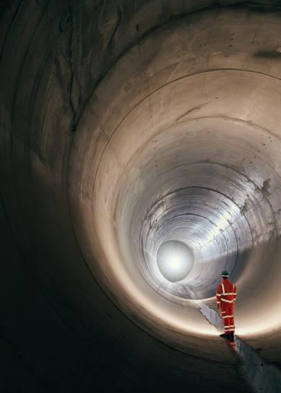 Worker standing in a sewer tunnel before operation.