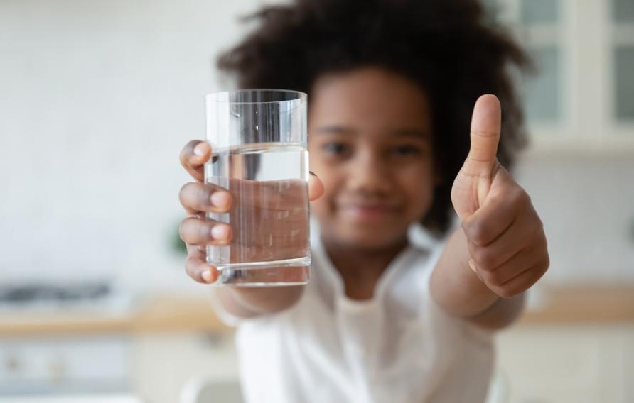 Hands holding glass with fresh pure water and showing thumbs up gesture