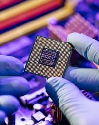 Laboratory technician holds a powerful processor in his hands. CPU computer processor shallow focus. CPU socket of the computer's motherboard. Concept of computer, motherboard, hardware and technology