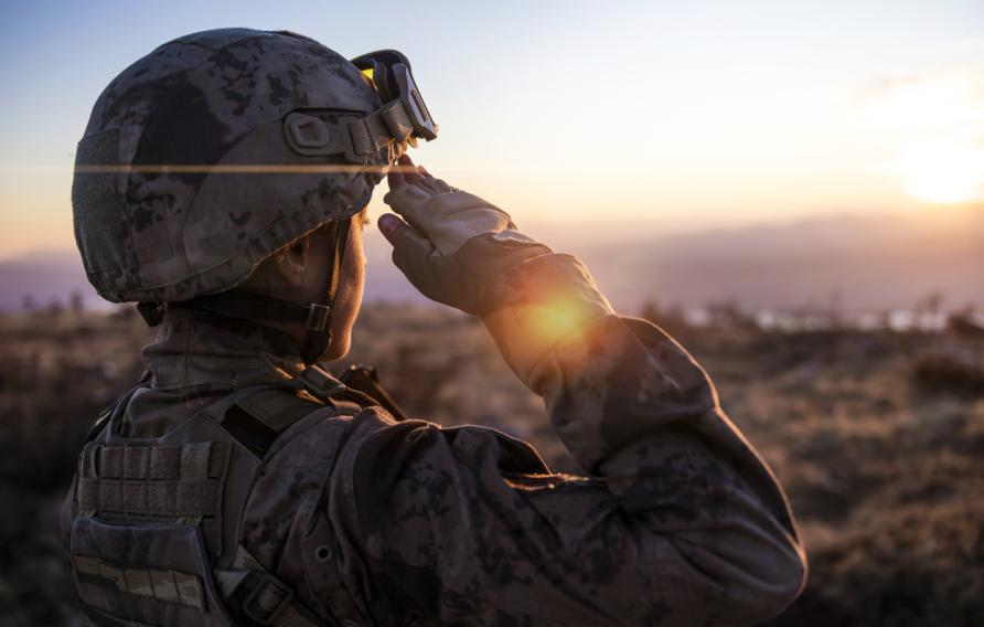 Female Army Solider Saluting against sunset sky