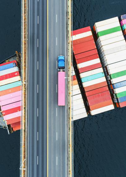 Shipping container sailing under a bridge