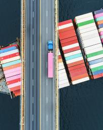 Shipping container sailing under a bridge